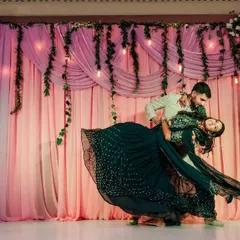 A couple lost in their own world during a dramatic and romantic dance at their reception.