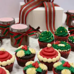 My Christmas collection, featuring festive cupcakes and jars of my house-made caramel sauce, all ready for gifting with beautiful holiday ribbons.