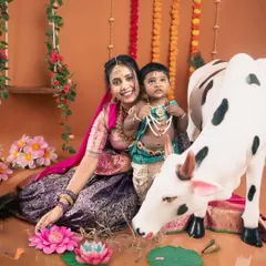 This little Krishna and his mom are posing with our life-sized cow prop, part of our grand Janmashtami setup. These sessions are filled with playful and traditional elements.