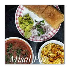 A plate of authentic Misal Pav, served deconstructed with the spicy sprout curry (usal), farsan, chopped onions, and pav.