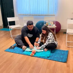 Parenting is a team effort. Here, Lynette and Peter practice swaddling a doll during our Newborn Care Workshop. This hands-on practice helps couples build confidence and learn essential skills together before their baby arrives.