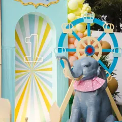 A close-up of the circus-themed decor, featuring a light-up number '1', a whimsical ferris wheel, and an adorable elephant prop. The pastel color palette gives this classic theme a soft and modern feel.