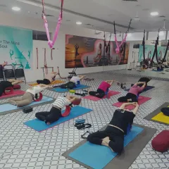 A group of students using yoga wheels for a supported backbend. This tool helps to open the chest and shoulders while protecting the lower back.