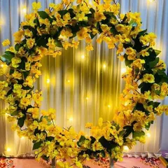 A simple yet elegant circular ring frame covered in cheerful yellow flowers. This minimalist design is set against a softly lit backdrop, making it a perfect choice for a modern and stylish celebration.