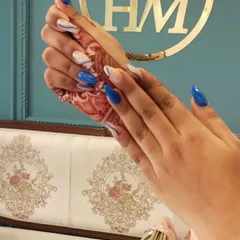 This is a great example of modern, graphic nail art. I combined a bold royal blue with a negative space background, using fine white and black lines to create a striking swirl pattern on these sharp stiletto nail extensions.
