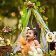 A happy moment from Shivya's outdoor jungle-themed shoot. The natural background complements the teepee and animal props perfectly.