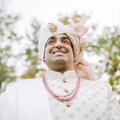 A low-angle shot of the groom looking up with a smile, exuding confidence and joy.