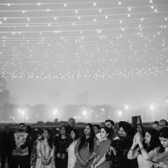 All eyes on the happy couple! This black and white shot captures the guests watching the celebration under a canopy of fairy lights, their faces full of love and happiness.