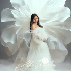 Embracing the beauty of new life with this ethereal portrait. The giant white flower prop adds a touch of fantasy to this classic white gown look in the studio.