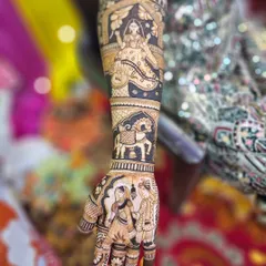 This design tells a story up the arm, with a couple portrait on the hand, a royal horse figure, and a beautiful bride in a jharokha window. The use of negative space makes the figures stand out.