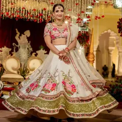 A beautiful bride twirls in a floral embroidered white and pink lehenga. This outfit is a fresh and modern choice for a day wedding or Anand Karaj ceremony, combining traditional grace with a light, celebratory feel.