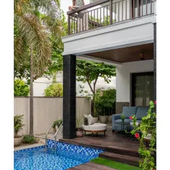 A view from the balcony overlooking the poolside lounge we created. The design includes a comfortable outdoor sofa on a wooden deck, with a clear view of the pool and surrounding greenery, making it a perfect private vantage point.