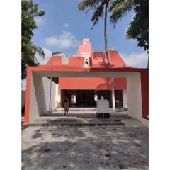 The main entrance gate of the Sai Temple in Trichy. The bold red color and modern form reinterpret the traditional temple 'gopuram' or gateway, creating a strong sense of arrival.
