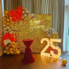 Make a bold statement with a glamorous gold sequin shimmer wall. Paired with a vibrant balloon garland, a custom neon sign, and light-up marquee numbers, this backdrop is designed for unforgettable 25th anniversary parties.