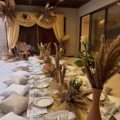 A long shot of the low-seating dinner arrangement for the Arabic-themed party. The setup is designed to feel communal and cozy, with plenty of cushions and warm lighting.