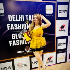 An influencer and award winner poses in front of our media wall, showcasing our key sponsors like Clinikally and Voods. We ensure our partners get prominent visibility with the creators and tastemakers who attend our events.