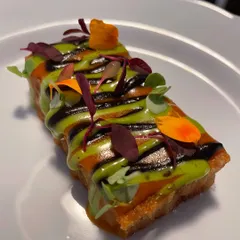 A close-up of a savory toast canapé, showing the vibrant colors and textures.
