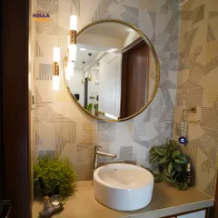 A closer look at the basin area, highlighting the modern vessel sink, stylish wall-mounted lights, and the beautiful texture of the wallpaper.