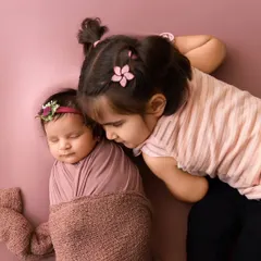 A gentle moment between an older sister and her sleeping newborn sibling. Sibling photography is a special part of my newborn sessions, capturing the start of a lifelong bond.
