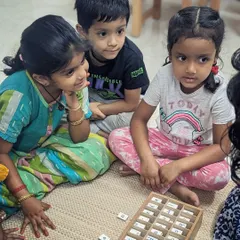 Here, a group of children are captivated by the Moveable Alphabet, a cornerstone of Montessori language learning. They work together, sounding out words and discovering the magic of language in a tangible, collaborative way.