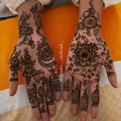 A close-up of the beautiful, asymmetrical design I created for my favorite client. One hand features a floral mandala, while the other has a delicate Arabic vine.