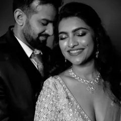 A classic and glamorous black and white close-up portrait of the couple, capturing the bride's joyful smile and the elegance of their reception look.