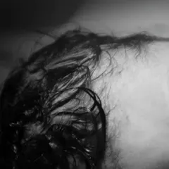 A close-up of the beautiful, wispy hair of a newborn right after birth. Black and white photography brings out the delicate textures of these first moments.