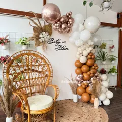 Celebrating a 'Baby in Bloom' with this chic, bohemian-themed baby shower. I used a warm, earthy palette of neutral and rose gold balloons, accented with dried pampas grass. The wicker peacock chair creates a beautiful focal point for the mom-to-be.