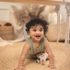 A big, joyful smile from this adorable crawler. The natural jute rug and boho props create a warm, earthy feel for this sitter milestone session.