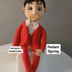 An example of a detailed fondant figurine of a man in a red suit, which can be used as a custom cake topper.
