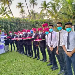 My welcome team, dressed in traditional turbans, holding trays of flowers to greet guests at a wedding entrance.