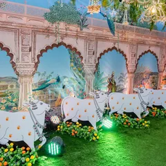 Detail shot of our Pichwai-themed decor, showcasing the hand-painted style wall panels depicting scenes from Vrindavan. The custom-made cow cutouts are placed along the walkway, adding a layer of authenticity and charm to the religious event.