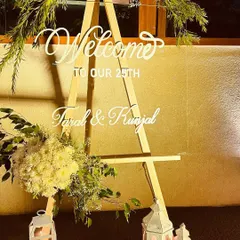 A personalized welcome sign is a small detail that makes a big impact. For this 25th-anniversary event, we created an elegant acrylic sign on a wooden easel, adorned with fresh flowers to greet the guests of honor.