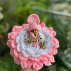 A lovely pink and white floral dress for Ladoo Gopal, adorned with little pearls. Each dress is made with soft yarn and lots of devotion.