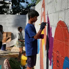 A young boy fully absorbed in adding a rich purple hue to our collaborative mural. It is in these quiet moments of concentration that you see the real connection happening between the artist and the artwork.