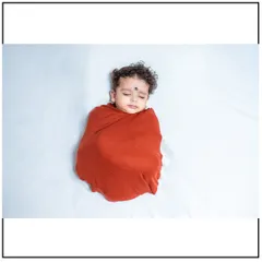 A peaceful moment from a newborn session. I ensure your baby is warm and comfortable, using soft, high-quality swaddles for these classic sleepy portraits.