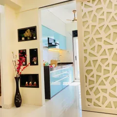 A view from the living area into the kitchen, separated by a decorative geometric partition. This demonstrates how a kitchen can be integrated into the home's overall design while maintaining a distinct zone.