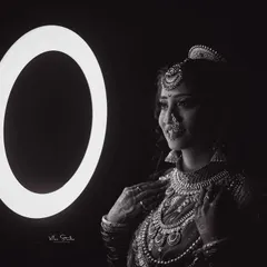 A dramatic black and white bridal portrait using a ring light. The high contrast and focused light create a moody and sophisticated image that highlights the bride's features and jewellery.
