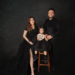 The whole family joins in to celebrate! This beautiful portrait captures the joy of a growing family, complete with a sweet "It's a Boy!" gender reveal sign against a magical starry backdrop.