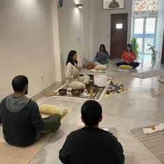 A moment of stillness during a sound healing session. Here, the instructor guides the group through breath awareness before immersing them in the healing frequencies of the bowls.