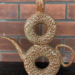 This unique, wheel-thrown double donut vase is also a functional teapot or watering can. It's a playful, artistic piece that is sure to be a conversation starter.