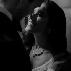 An intimate black and white close-up of the couple during their reception. The soft lighting and genuine smiles make this a beautifully romantic and candid shot.