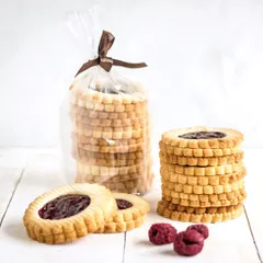 Our Raspberry Jam Ring cookies, a buttery shortbread cookie with a sweet raspberry jam center. Their delicate, scalloped edge makes them as beautiful as they are delicious.
