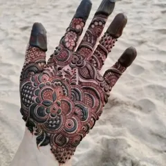 A beautiful and intricate design captured at the beach. The fine details and shading are still visible even with the dark paste.