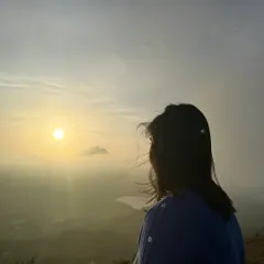 A trekker watches the sun rise over a hazy valley from the top of Uttari Betta. It's a truly magical start to a Sunday.