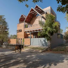 This is the Madhura residence, designed as two homes stacked together. I used compressed stabilized earth blocks (CSEB) and prominent sloping tile roofs to connect the design to the family's ancestral roots while creating a modern, functional urban home with a generous front garden.