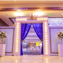 The majestic entrance to a prince's birthday party. The crown-topped archway with warm lights and royal blue drapes sets a regal tone from the moment guests arrive.
