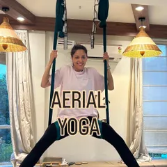 A student finds her balance and joy while suspended in the aerial silk. This pose helps open the hips and build strength in the arms and core, all while feeling weightless.