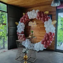 Our circular balloon arches are perfect for framing the bride to be. This setup includes elegant pedestals for placing the cake or gifts, and the 'Bride to be' neon sign adds a warm, celebratory glow to the entire arrangement.