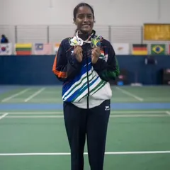 **A Display of World-Class Achievement.** Aaditya Yadav stands proudly with her collection of medals from the World Deaf Championship, a monumental achievement for her and the academy.